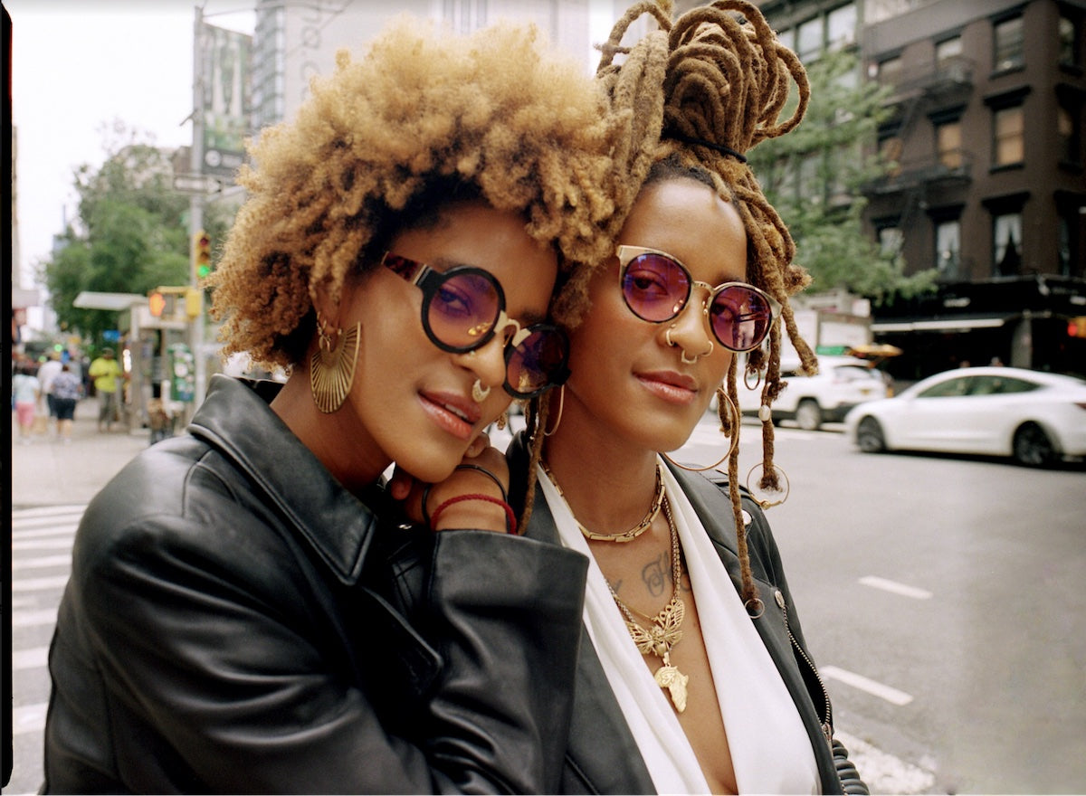 一个image of Coco and Breezy posing on a busy street wearing sunglasses and leather jackets