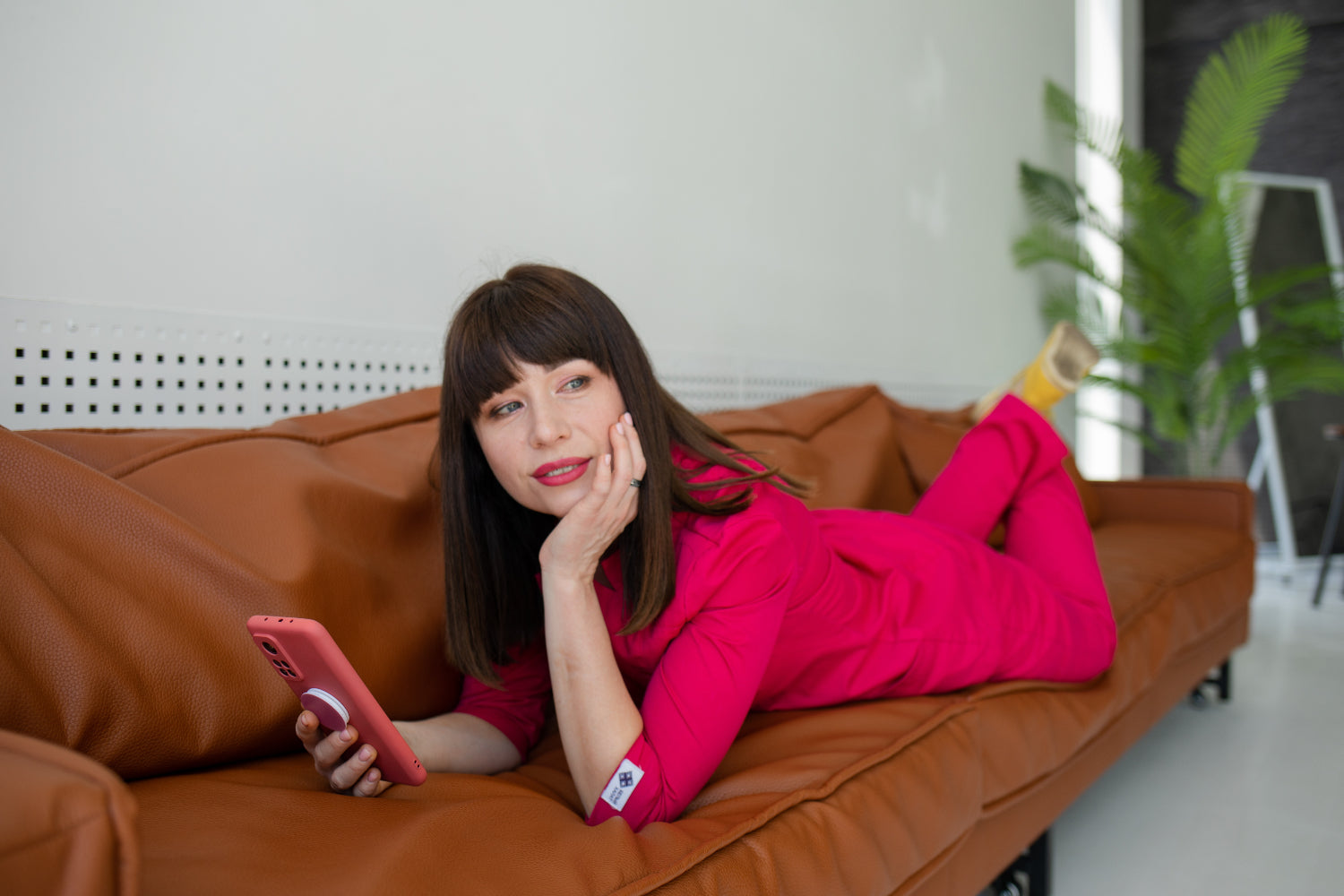 Woman lounges on a sofa with a mobile phone in her hands