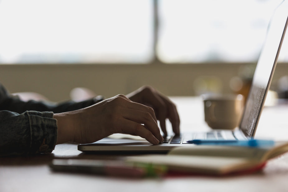 Shadow hands typing at laptop computer