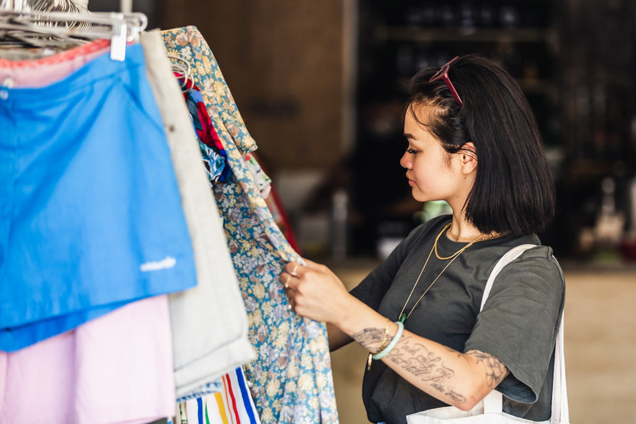 Person looks at clothing items on rack