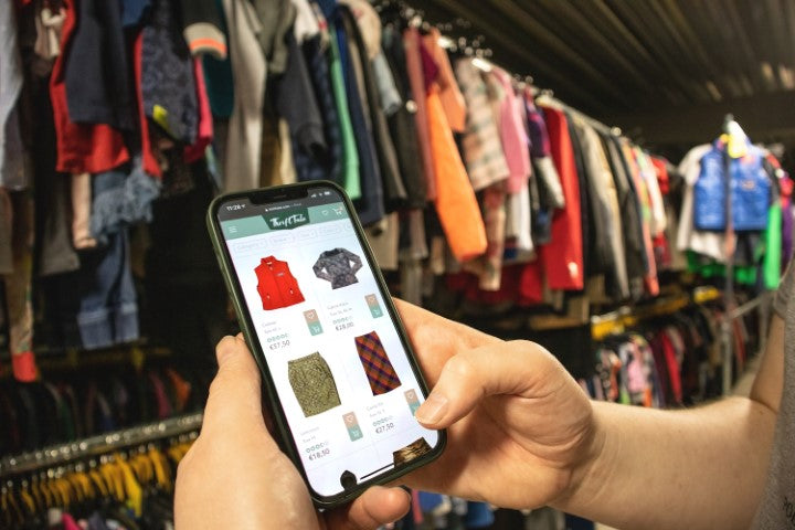 Telefoonscherm met daarop de productpagina van een online tweedehands kledingwinkel