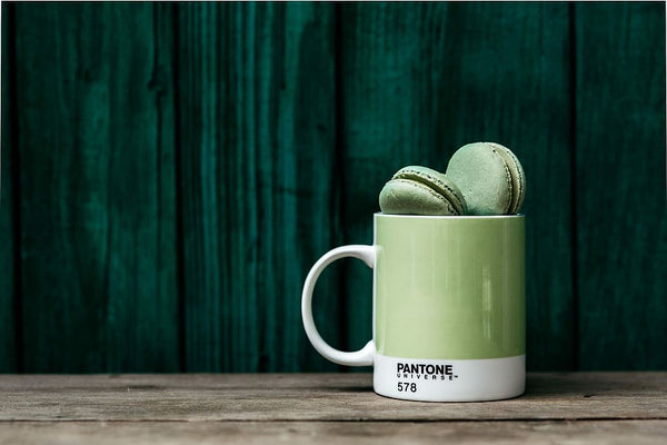 caneca verde da pantone personalizada com macaroons de pistache sobre fundo verde
