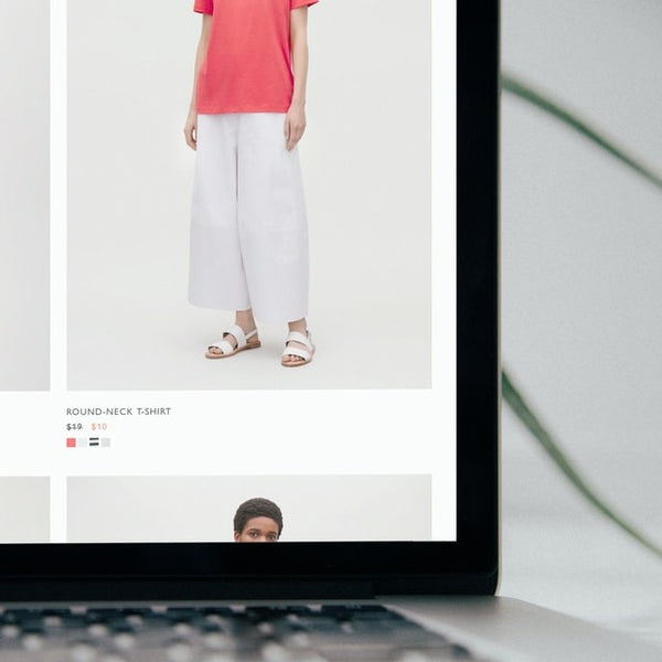 Foto de um laptop aberto com o site de uma loja de roupas.